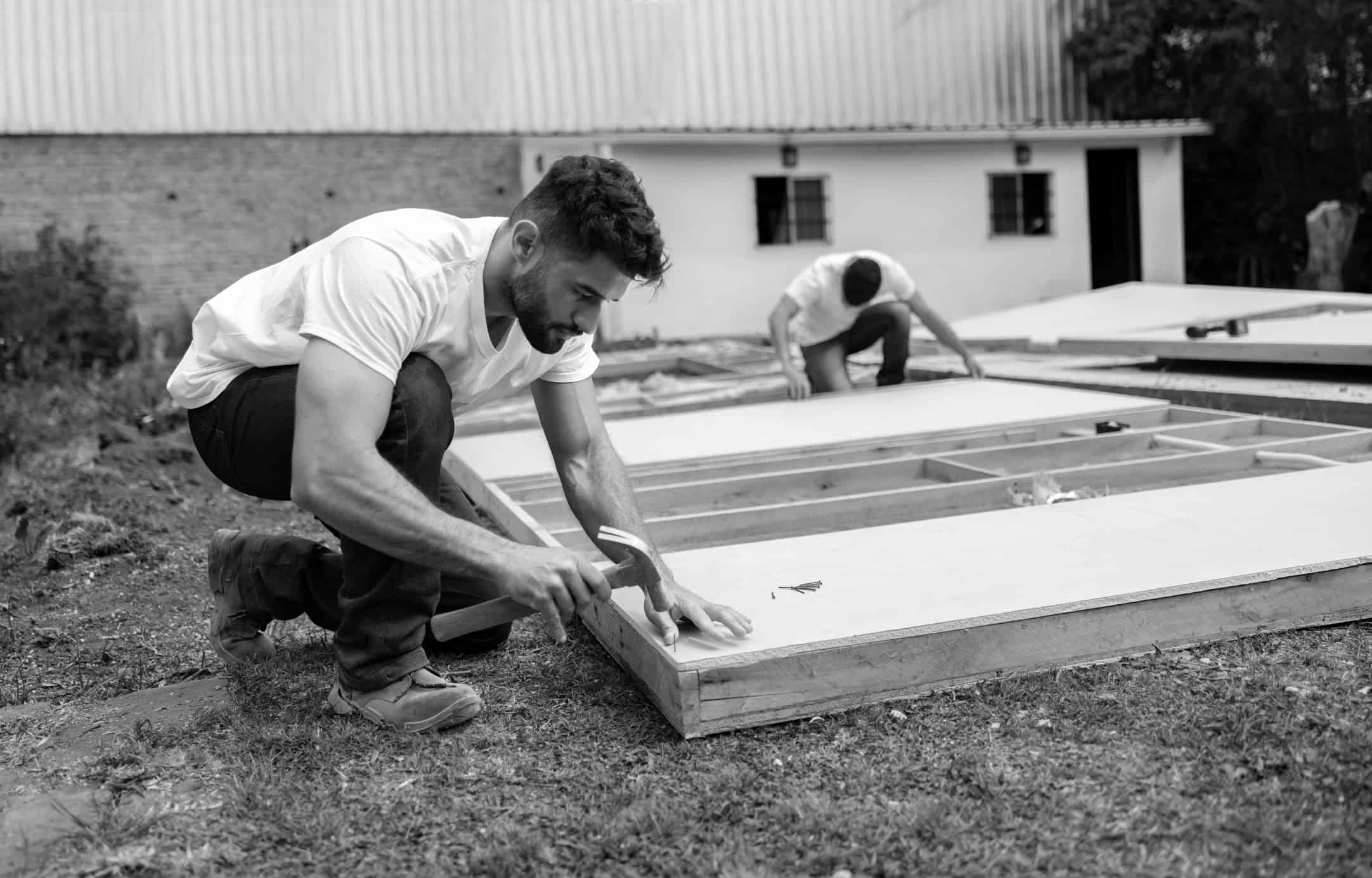 Man hammering a nail on wood panel