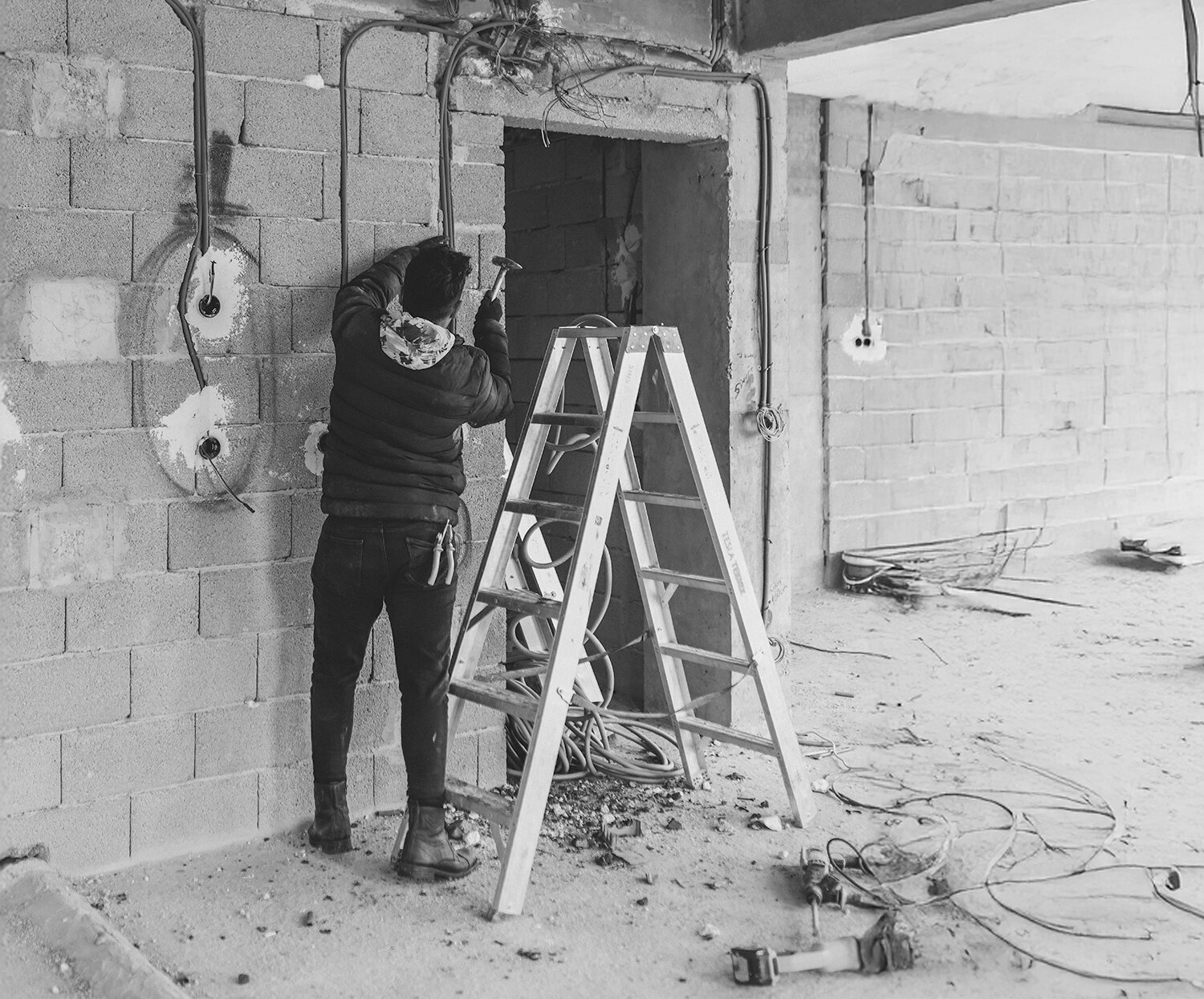 man working in building site hammering wall