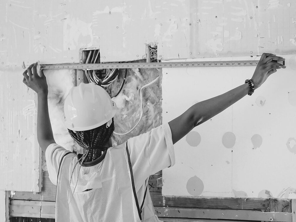 Smarter scheduling for home visit teams woman working on building site measuring a wall