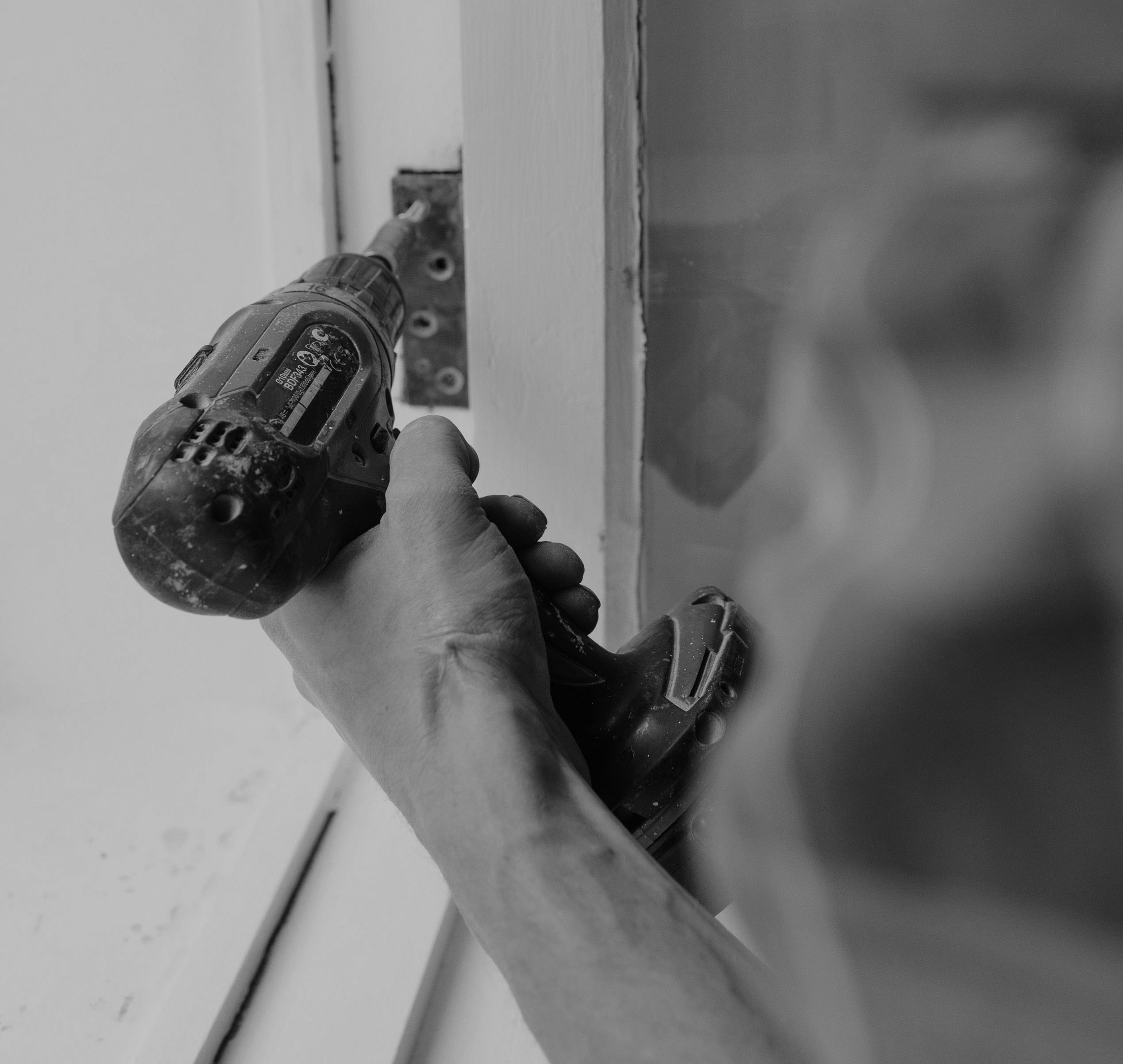 Smarter scheduling for housing and property teams man holding drill in house renovation
