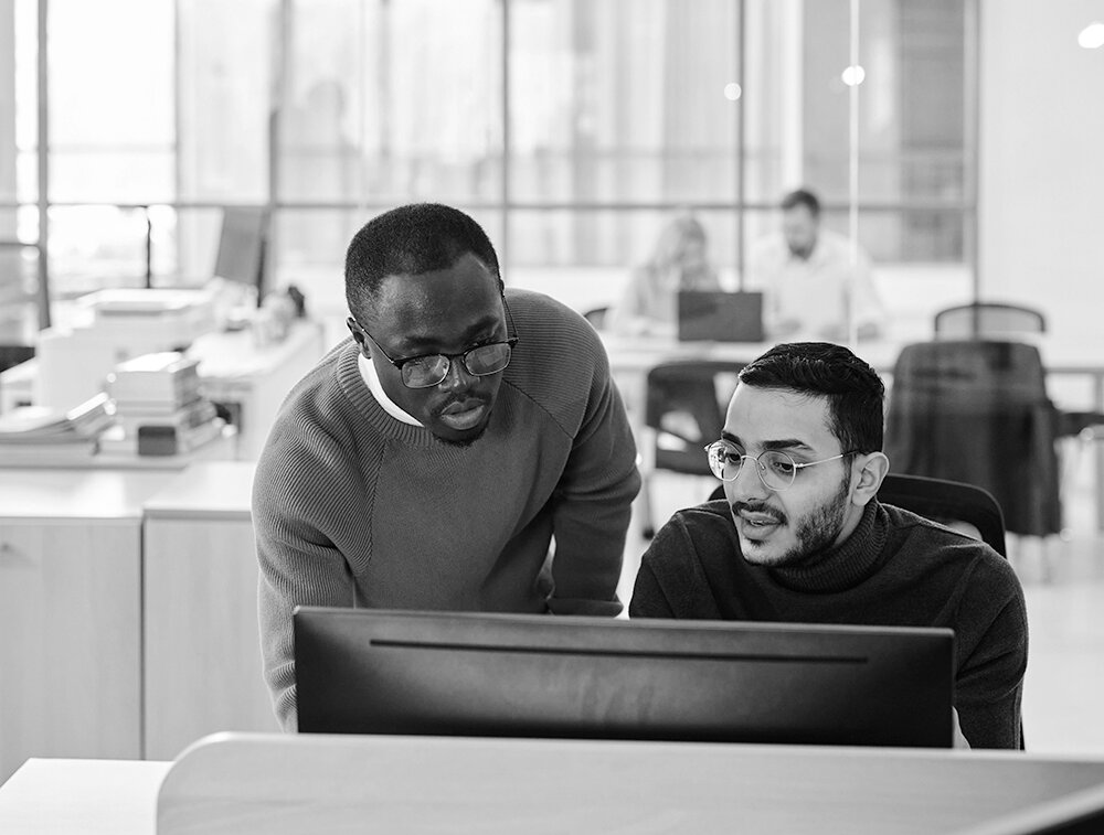 Two employees looking at computer screen