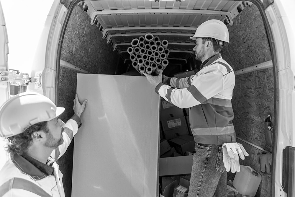Two builders loading van
